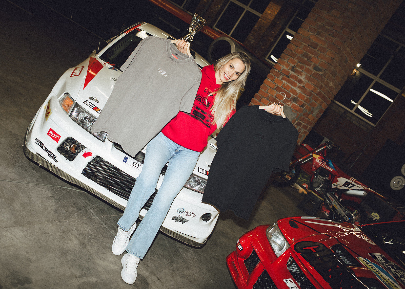 Forever Classic rally clothing collection with grey and black T-shirts beside Mitsubishi Evo cars
