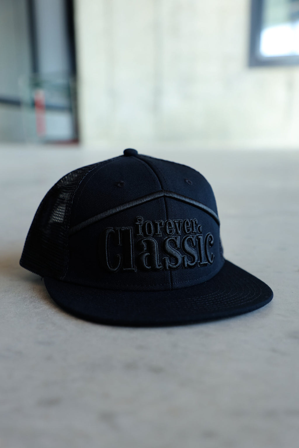Forever Classic black snapback cap with flat brim, mesh back and adjustable closure