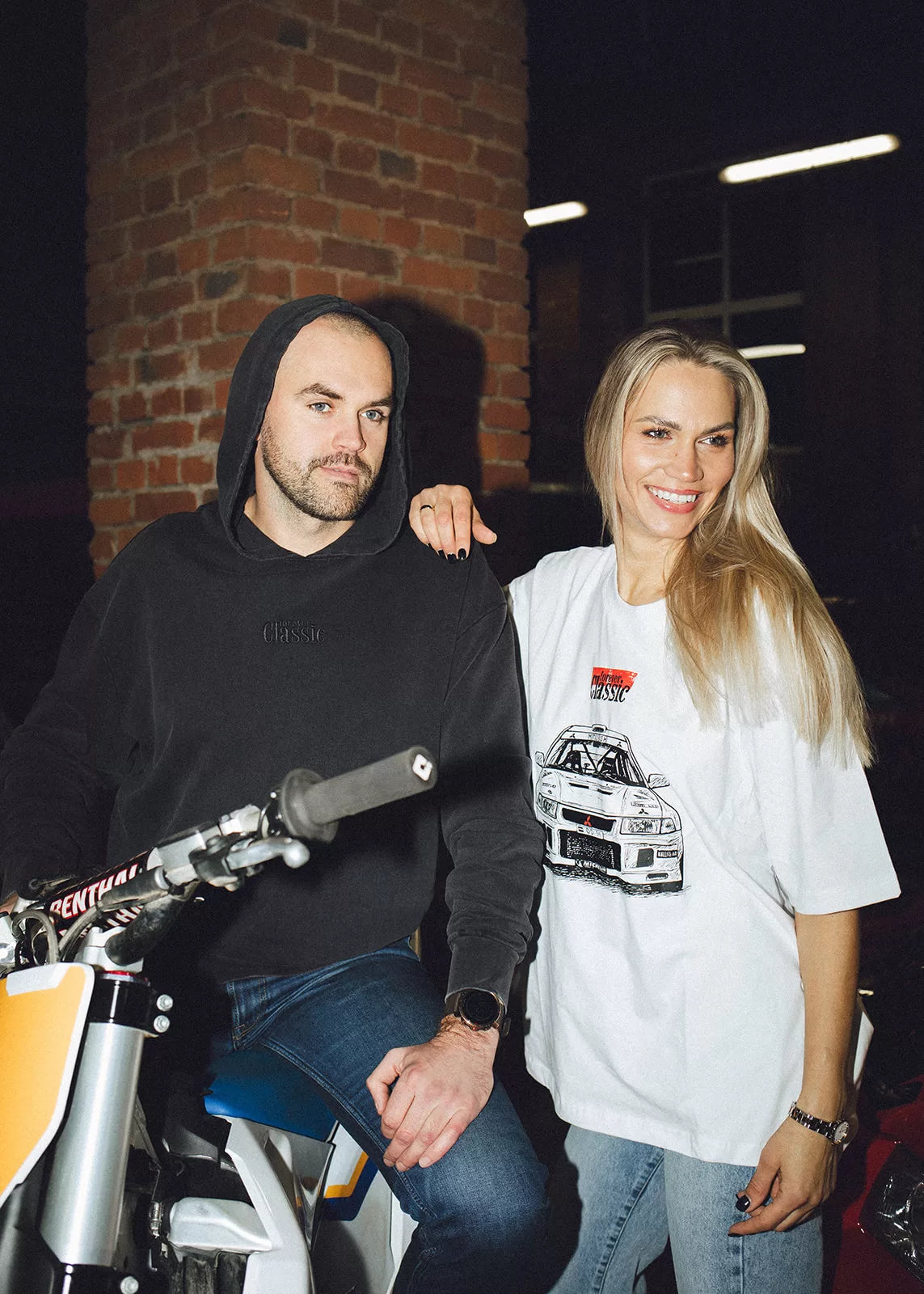 Couple in Forever Classic streetwear posing with a motocross bike